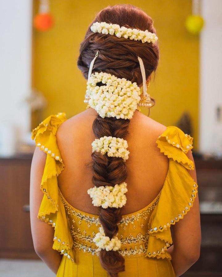 Photo of haldi bridal look with floral jewellery and side braid