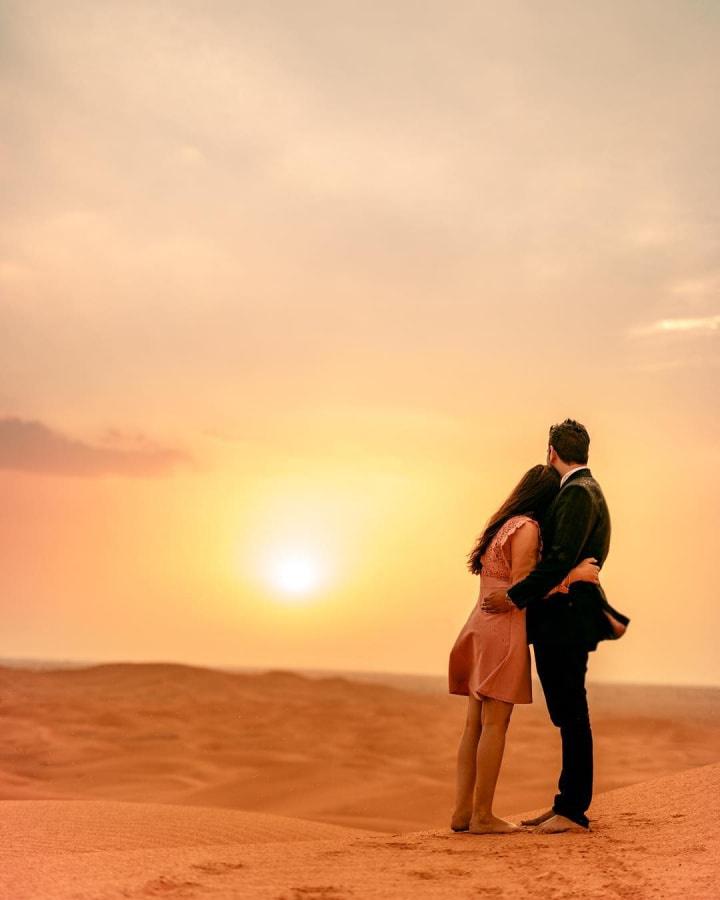 Premium AI Image | woman poses during sunset at the mountains in the style  of light aquamarine and indigo