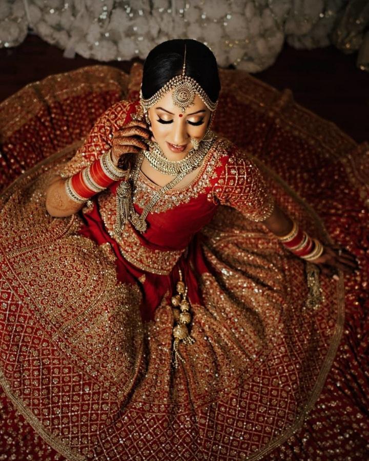 Photo of Strawberry Red Lehenga with Green Statement Jewellery