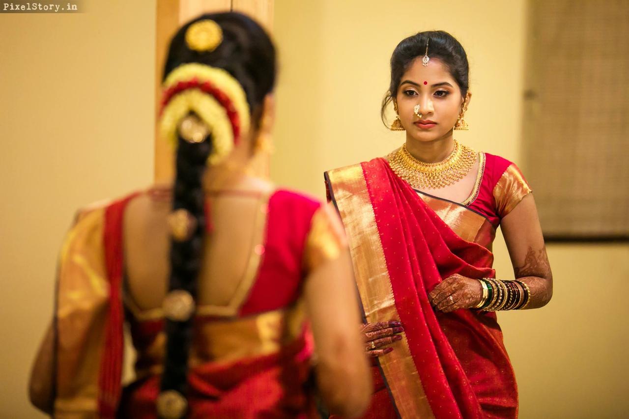 Photo of South Indian bride in a navy blue saree with red border.