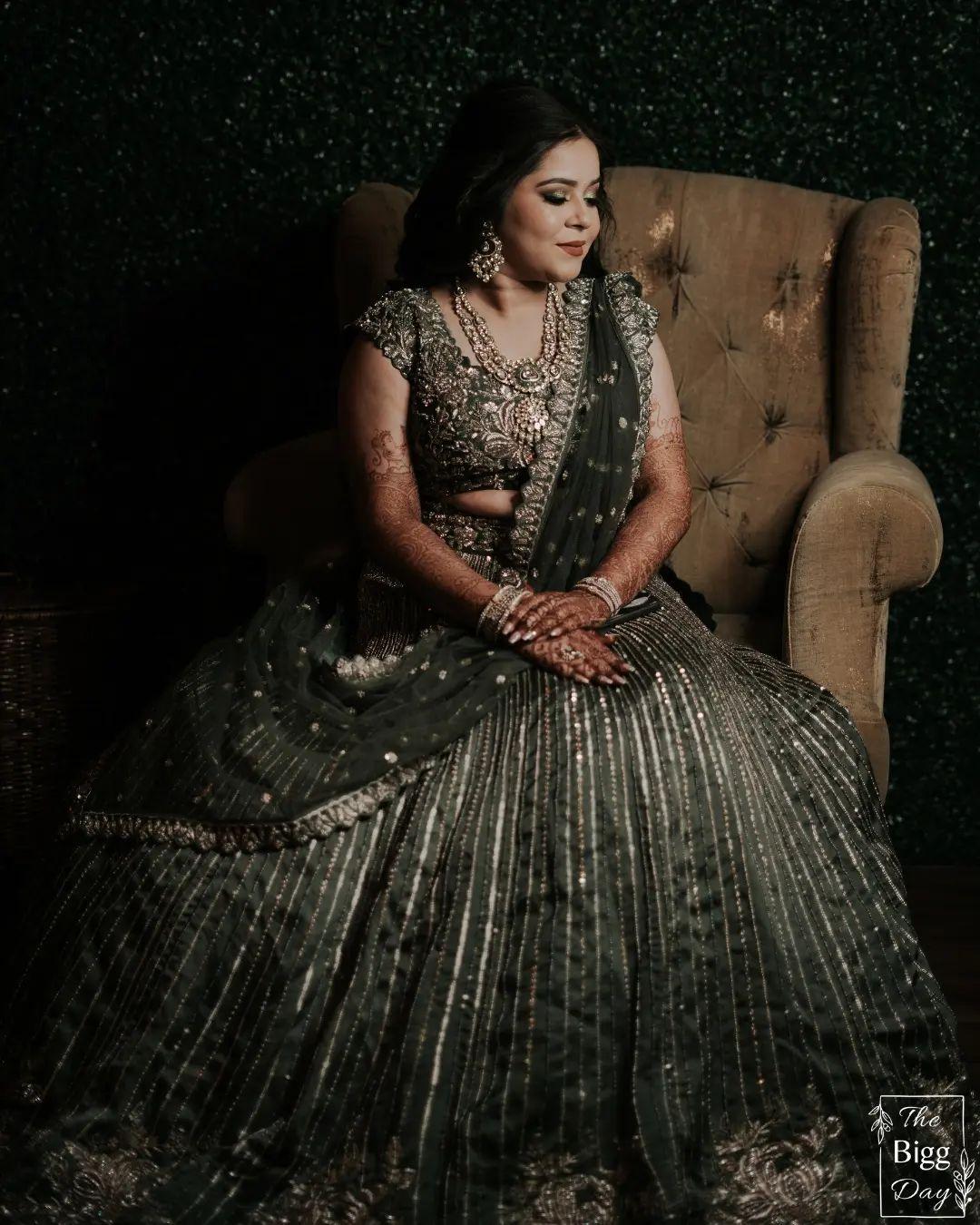 Photo of Bride looking down in lehenga with cape sleeves