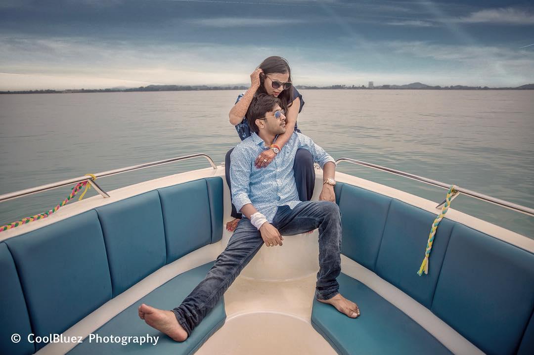 Portrait of romantic couple sitting in boat on beach stock photo - OFFSET
