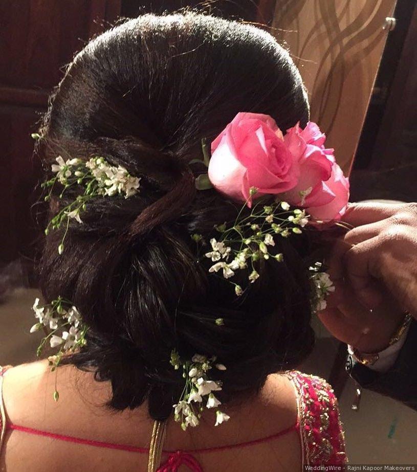 Photo of A twisted bridal bun outlined with white flowers.