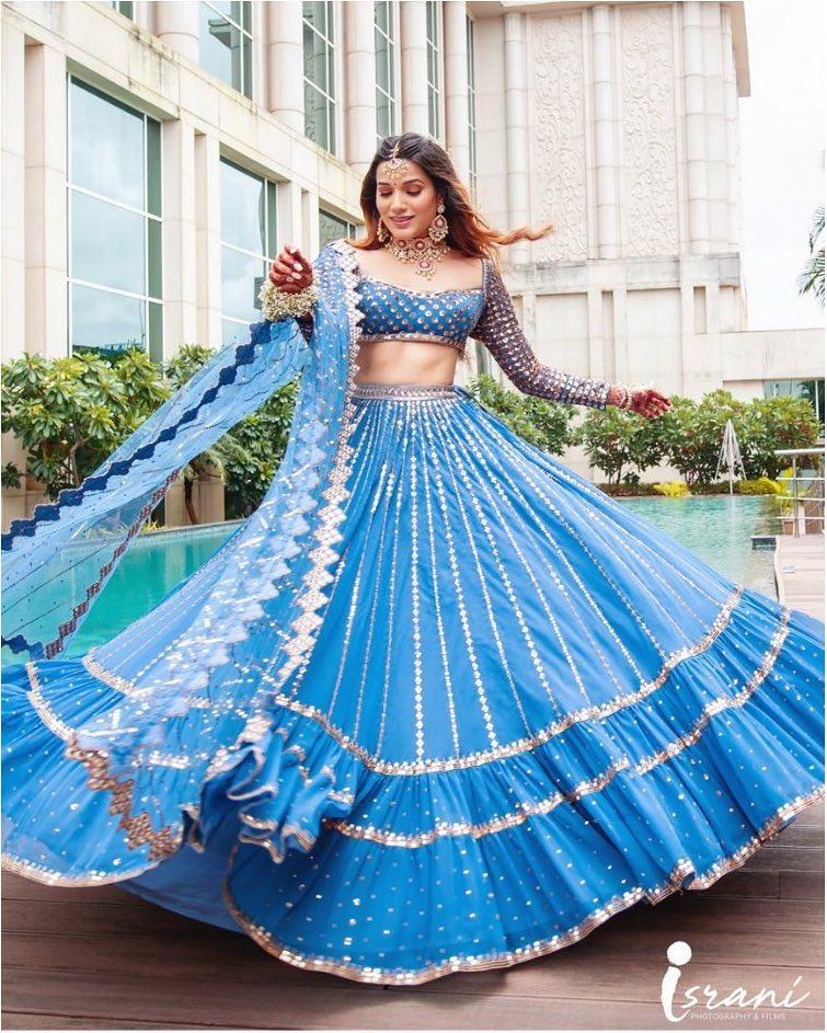 Photo of An off-shoulder engagement lehenga coupled with heavy earrings.