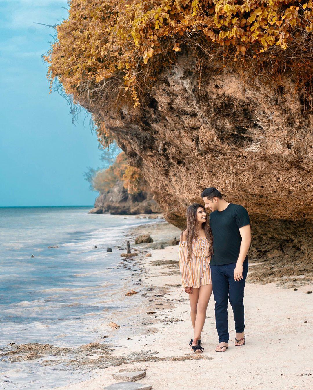 Couple Of Smiling Caucasian Girls In Summer Dresses Sitting On Rocks  Against The Sea Stock Photo - Download Image Now - iStock