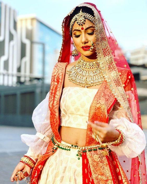 Photo of modern bengali bride in red and gold sabyasachi lehenga