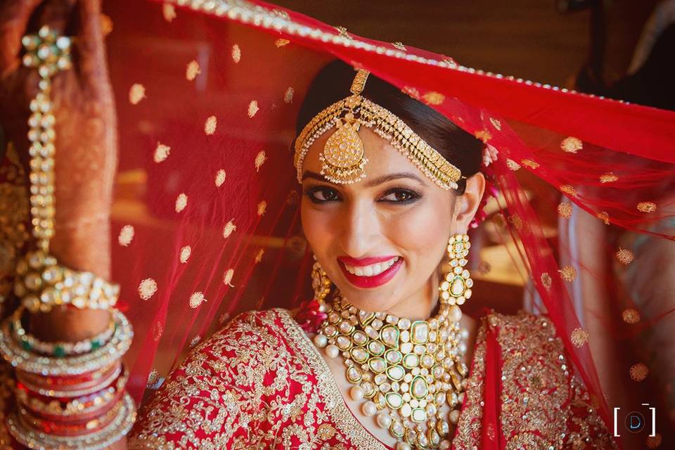 Photo of Bride in offbeat blue lehenga and gold jewellery