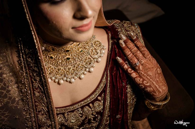 Photo of bride in white lehenga with antique gold jewellery