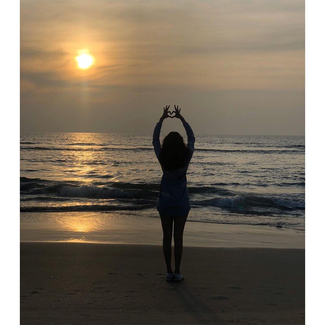 Black Female Doing Ashta Chandrasana Pose On Seashore