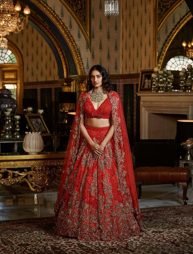 Photo of Twirling Sikh bride in red and gold bridal lehenga