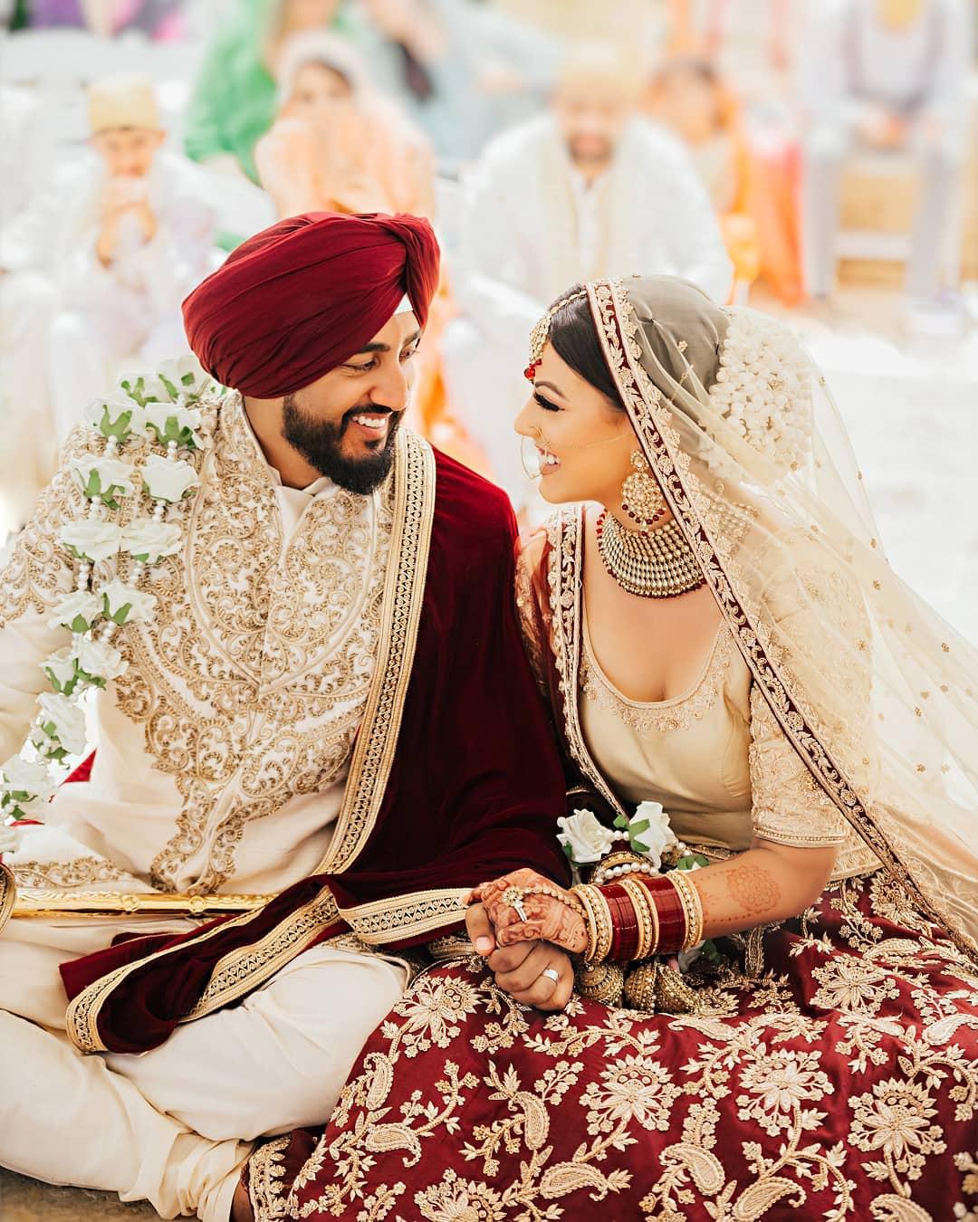 Young Indian Bride groom posing for photograph. Groom kissing the forehead  of bride. The couple is wearing traditional indian wedding dress which is  designer lehenga for bride and sherwani for groom. Stock-bilde |