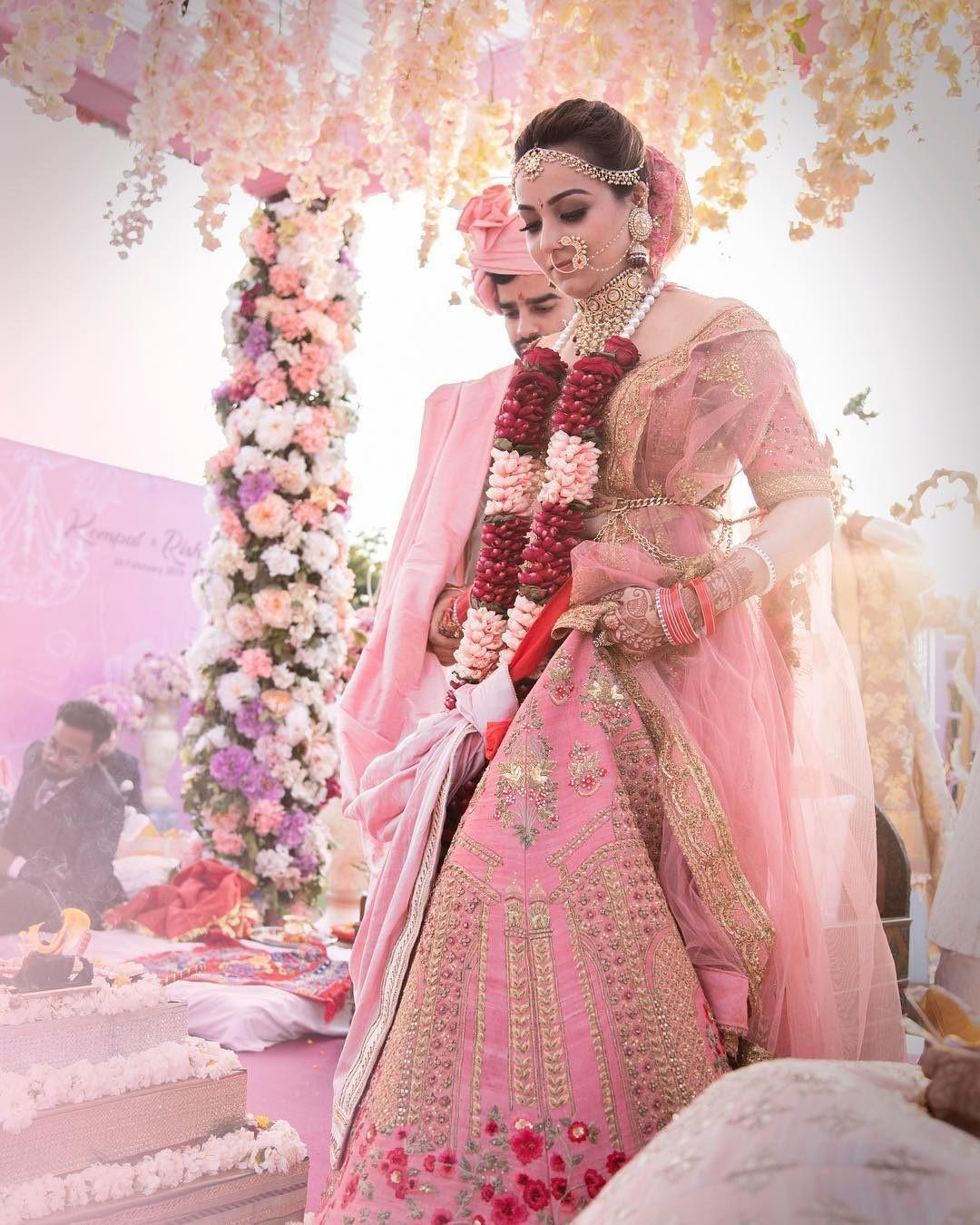 CHERRY PINK BANARASI LEHENGA SET PAIRED WITH A MATCHING BANARASI DUPATTA  AND CLASSIC BLOUSE WITH A GOLD EMBROIDERED NECKLINE. - Seasons India