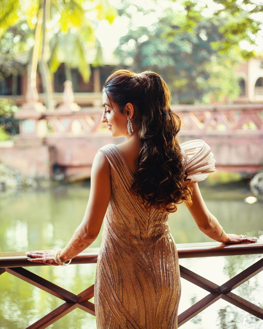 Trendy girl sitting on wooden bench. Keeping modish bag on bench. Looking  down, taking care of