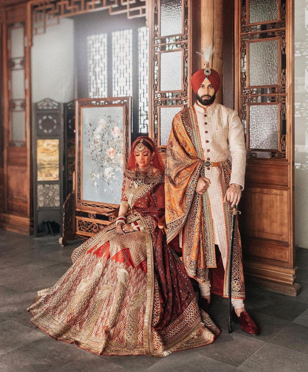 Photo of A royal sikh couple posing on their wedding day.