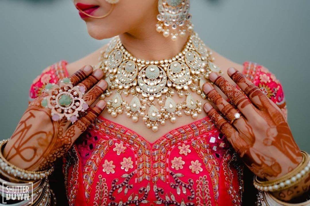 Photo of Maroon bridal lehenga with green contrasting jewellery